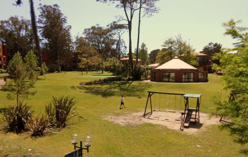 two people playing on a swing set in a park at Rincon del Este Resort in Punta del Este