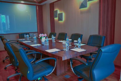 a conference room with a long wooden table and chairs at Nagoya Hill Hotel Batam in Nagoya