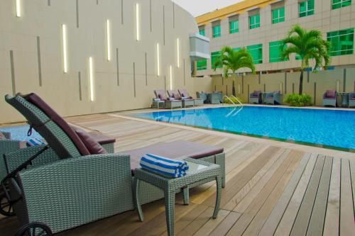 a swimming pool with chairs and a hotel at Nagoya Hill Hotel Batam in Nagoya