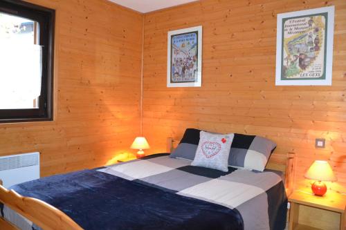 une chambre avec un lit dans un mur en bois dans l'établissement Praz-du-Soleil F3, aux Gets