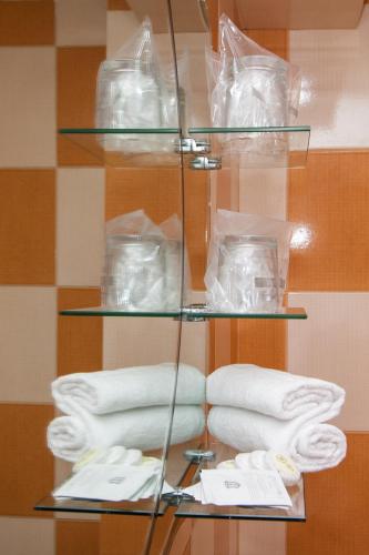 a glass shelf with towels and other items on it at Complex Mona Caraiman in Buşteni
