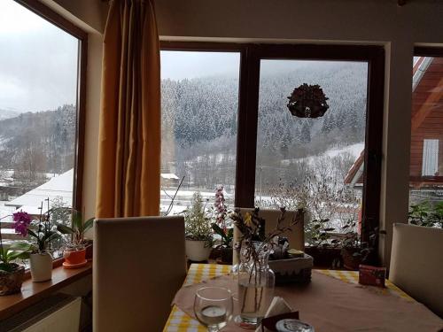 a dining room table with a view of a snow covered mountain at Pensiunea Casa Motilor in Bucium