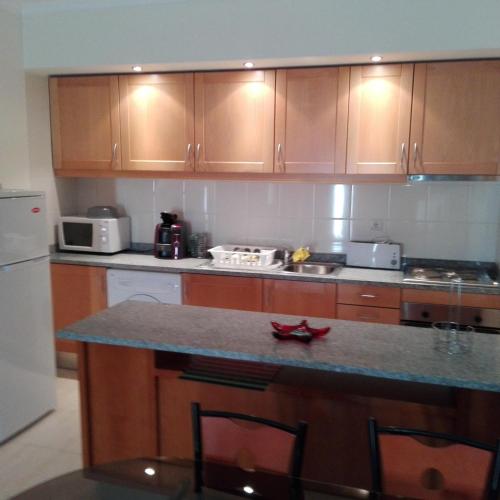 a kitchen with wooden cabinets and a counter top at Faia Atlantico Apartment in Portimão