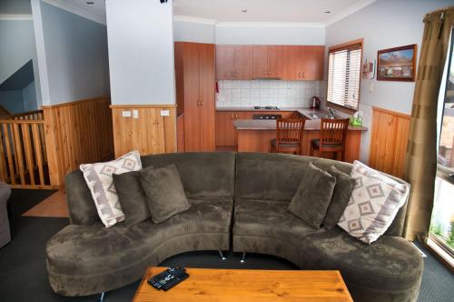 ein Wohnzimmer mit einem Sofa und einem Tisch in der Unterkunft Whistler in Bright