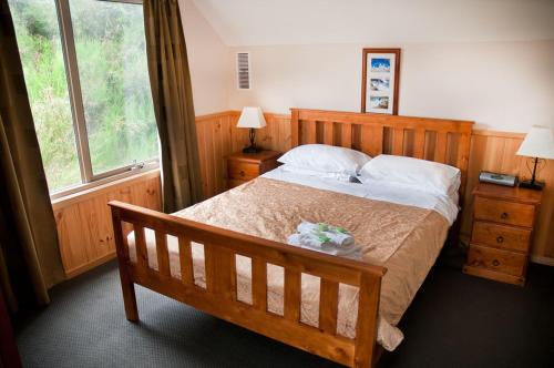 sypialnia z drewnianym łóżkiem i oknem w obiekcie Whistler w mieście Bright
