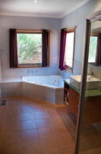 a bathroom with a tub and a sink and a bath tub at Whistler in Bright