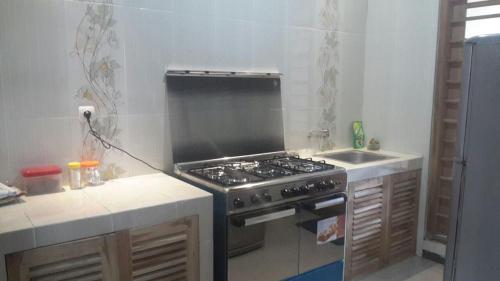 a kitchen with a stove and a sink at Homestay Syariah Grahadi in Malang