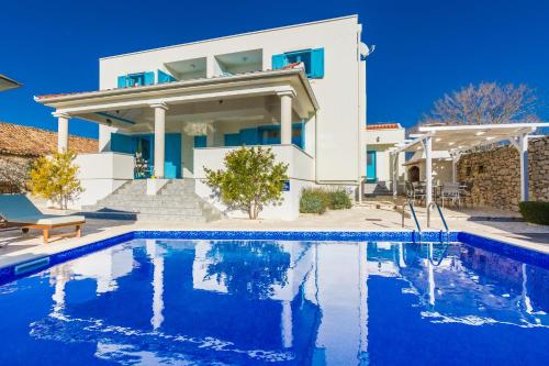 a villa with a swimming pool in front of a house at Wellness & Spa Villa Spirini Dvori in Poljica