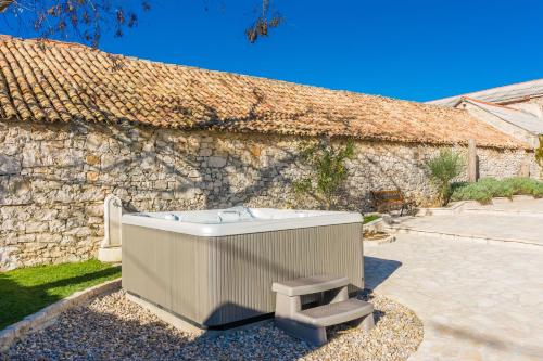 a bath tub sitting next to a stone building at Wellness & Spa Villa Spirini Dvori in Poljica