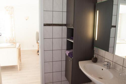 ein Bad mit einem Waschbecken und einem Spiegel in der Unterkunft Havneby Kro in Havneby