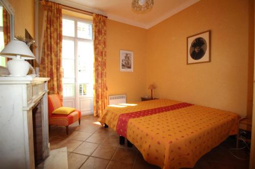 カンヌにあるAGENCIA appartement Rue d'Antibesのベッドルーム1室(ベッド1台、椅子、窓付)