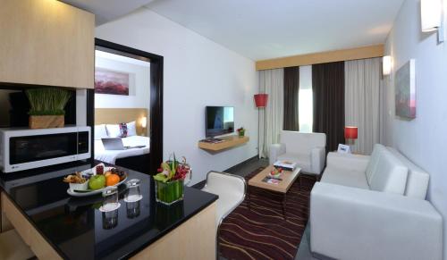 a living room filled with furniture and a tv at ibis Seef Manama in Manama