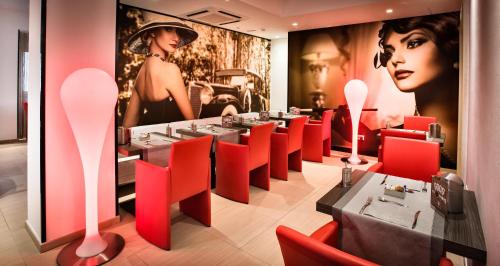 a restaurant with red chairs and a table in a room at Grand Hotel Resort&SPA Ma&Ma - Adults Only in La Maddalena