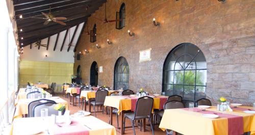 ein Esszimmer mit Tischen und Stühlen und einer Ziegelwand in der Unterkunft Resorte Marinha Dourada in Baga