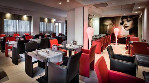 a dining room with tables and red chairs at Grand Hotel Resort&SPA Ma&Ma - Adults Only in La Maddalena