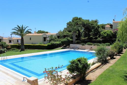 a large swimming pool in a yard with trees at Pasha Bay Residence in Sounio