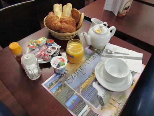 a table with a breakfast of bread and orange juice at Ker Annick in Saint Malo