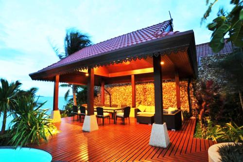 a wooden deck with a gazebo with tables and chairs at Erawan Villa Hotel in Bangrak Beach