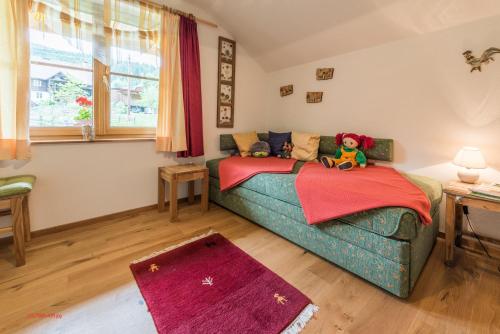 un dormitorio con un sofá con animales de peluche en Almliesl STGE-483 en Allgaueck
