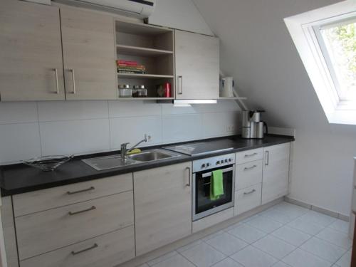 a white kitchen with a sink and a stove at Appartement Munz in Kirchheim unter Teck