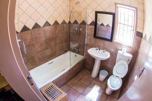 a bathroom with a tub and a toilet and a sink at Horseshoe Inn and Conference Center in Kimberley