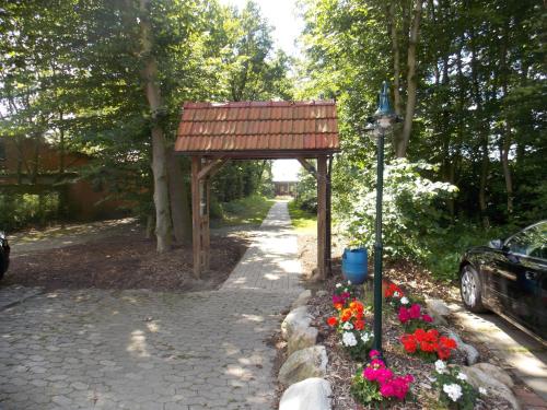 a garden with a sign and flowers on a path at Angelhof Weseloh in Karolei
