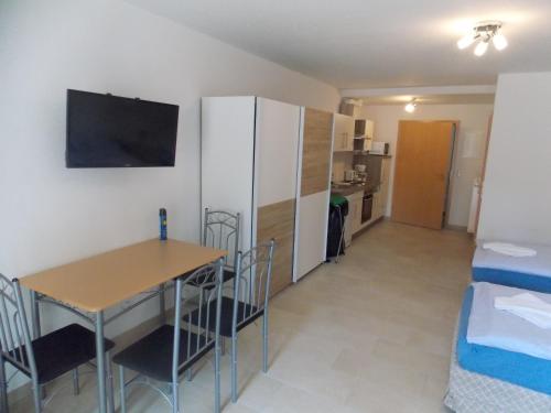 a small room with a table and a refrigerator at Angelhof Weseloh in Karolei