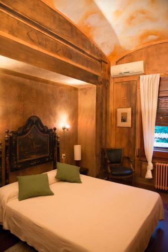 a bedroom with a large bed with two green pillows at Santa Ana B&B in Darnius
