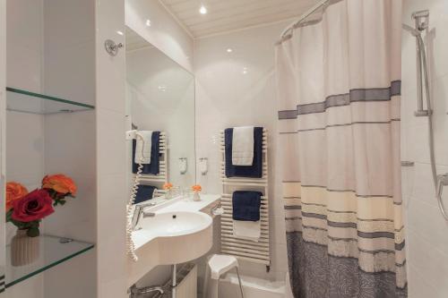 ein weißes Bad mit einem Waschbecken und einer Dusche in der Unterkunft Hotel Celina Niederrheinischer Hof in Krefeld