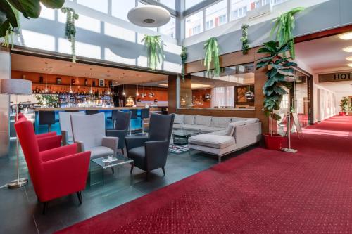 a lobby of a hotel with red chairs and a bar at Best Western Hotel Vista in Ostrava