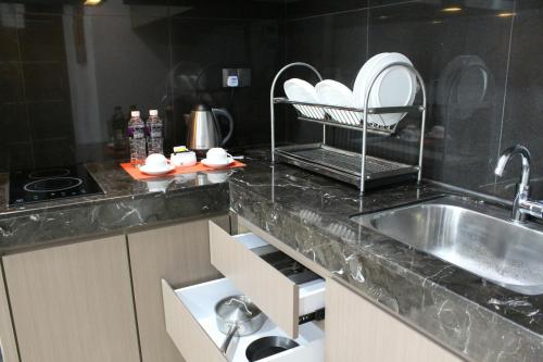 a kitchen with a sink and a counter top at The Centro Hotel & Residence By Orchardz in Batam Center
