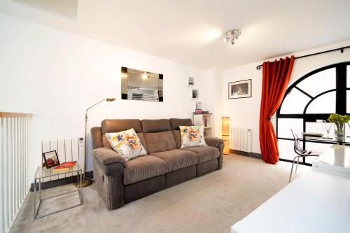 a living room with a brown couch and a window at Exclusive 1 Bed Flat Close To St Paul's Cathedral in London