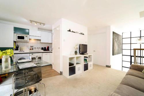 a kitchen and living room with a couch and a table at Exclusive 1 Bed Flat Close To St Paul's Cathedral in London