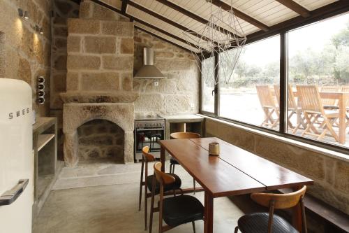 una sala da pranzo con tavolo e camino di Casa Estrela a Juncais