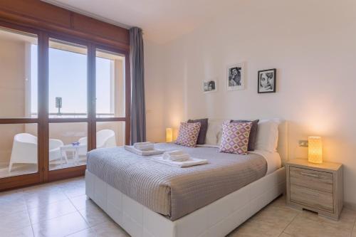 a bedroom with a large bed and a balcony at Residenze Su Planu in Cagliari