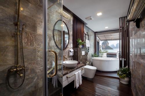 y baño con bañera, aseo y lavamanos. en Orchid Trendy Cruise, en Ha Long