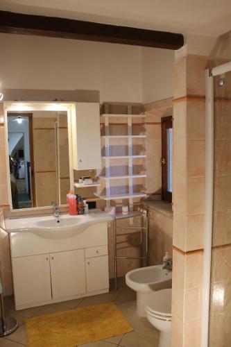 モンテプルチャーノにあるCasa Collazziのバスルーム(洗面台2台、トイレ、鏡付)