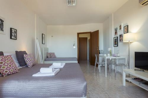 a living room with a bed and a dining room at Residenze Su Planu in Cagliari