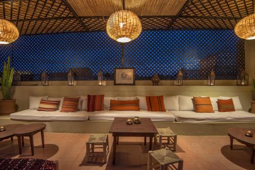 een woonkamer met een bank met kussens en tafels bij Riad Adika & Spa in Marrakesh