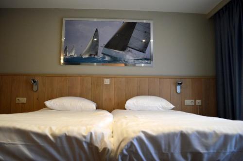 a hotel room with two beds and a television at Hotel Honfleur in Middelkerke
