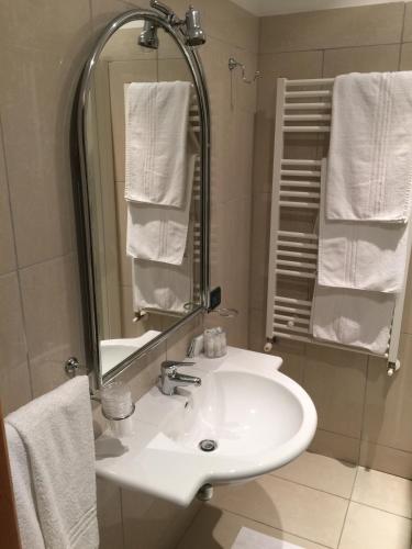 ein Badezimmer mit Waschbecken, Spiegel und Handtüchern in der Unterkunft Hotel Ottagono in Andria