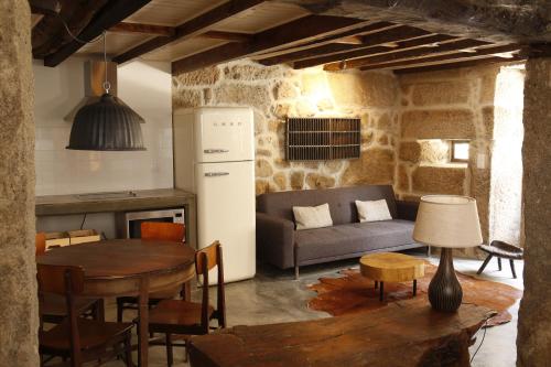 a kitchen and living room with a table and a couch at Casa Estrela Loft in Juncais