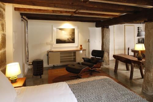 a bedroom with a bed and a desk and a chair at Casa Estrela Loft in Juncais