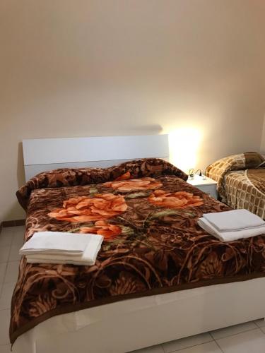 Una cama con una manta con dos servilletas. en B&B Cappellini s.n.c., en Roma
