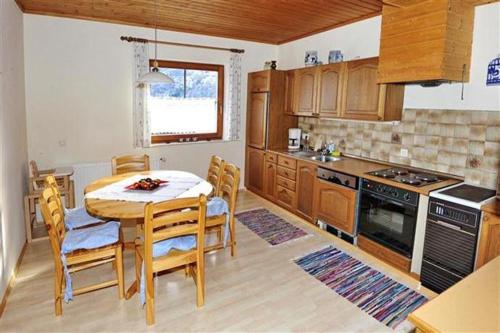 a kitchen with a table and chairs in a kitchen at Surtmannhof in Sirnitz