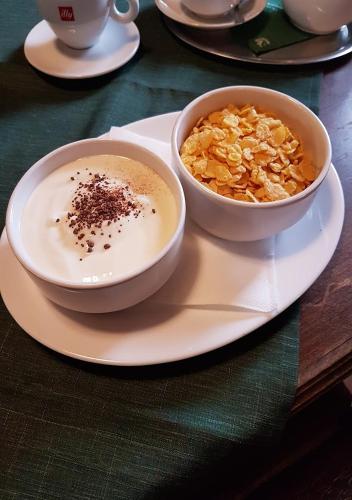 a bowl of cereal and a bowl of soup on a plate at Pension Dymník in Rumburk