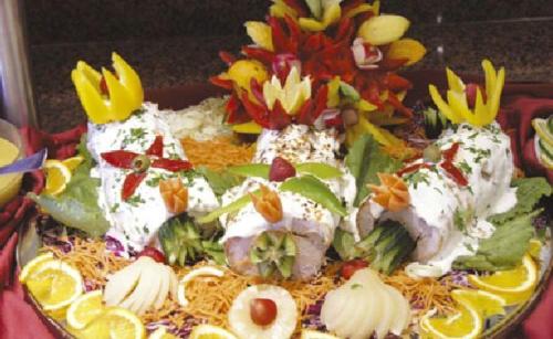 a plate of food with chicken and flowers on it at Vantaris Luxury Beach Resort in Georgioupolis