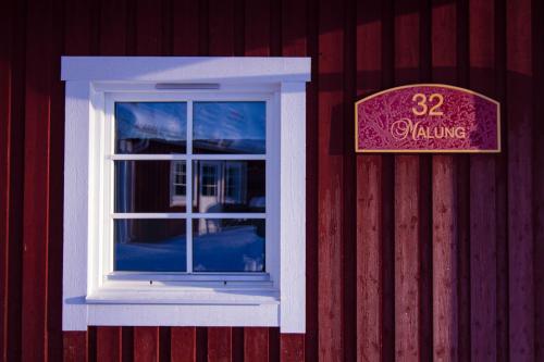 a window on the side of a red building with a sign at First Camp Moraparken - Dalarna in Mora