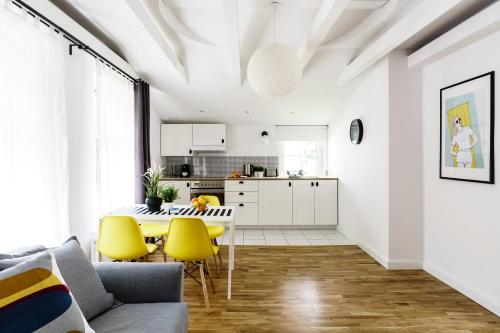 ソポトにあるStockholmのキッチン(テーブル、黄色い椅子付)が備わるリビングルームです。