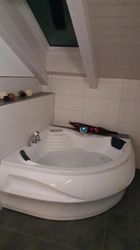 a white bath tub sitting in a room at Attika Wohnung Spiez in Spiez